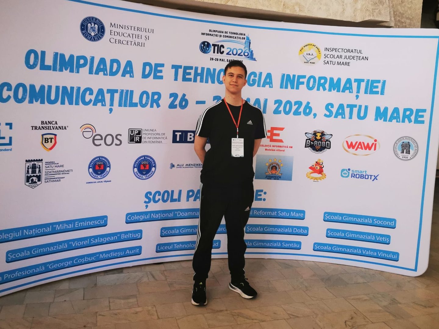 Alex in front of the ICT Olympiad 2026 banner in Satu Mare